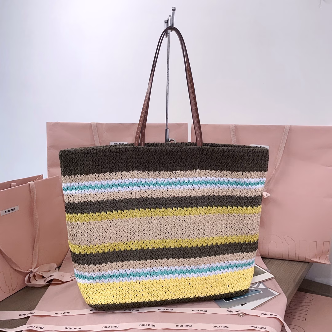 This imported Lafite straw woven cotton-padded tote bag features a fresh and pleasant blue tone. The unique weaving texture adds a touch of retro charm, making it both high-end and girlish. The front is adorned with the signature MiuMiu embroidery. The interior is made of cotton fabric, which is extremely light and has a large capacity. It is a must-have for outings and suitable for all seasons. The actual item is super beautiful