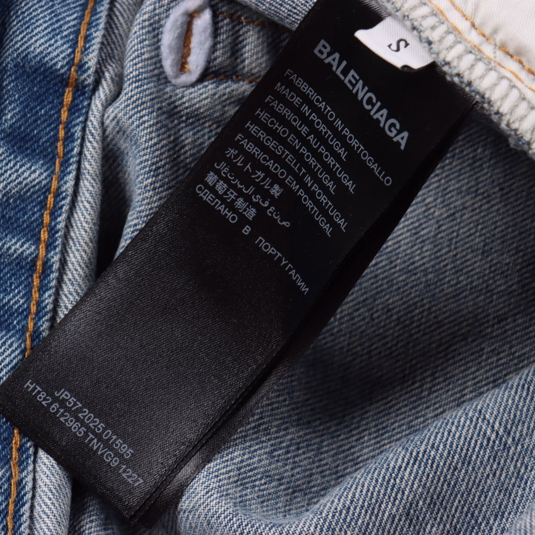 Balenciaga 25ss BAGGA wide-leg denim trousersIt is made of high-density cotton denim fabric and processed through a special blending technique, incorporating a trace amount of elastic fibers to enhance wearing comfort. The fabric undergoes multiple stages of water washing treatment, including enzyme washing, stone grinding and hand brushing, to create a natural fading effect and present a retro and aged texture. The yarn is spun by ring spinning technology to enhance the fabric's toughness and texture layering, ensuring a balance between stiffness and softness. Based on the classic straight-leg style, the leg lines are optimized through precise three-dimensional cutting. The front and rear pieces are spliced with a slight taper, ensuring a drape while avoiding bulkiness. The waistband design of the trousers may incorporate hidden adjustment loops, balancing a good fit and minimalist aesthetics. The buttons are made of specially crafted alloy and have undergone an aged coating treatment, engraved with the brand's signature LOGO. The rivets and zippers are made of the same series of metals and have passed salt spray tests to ensure oxidation resistance. At the same time, they maintain a rough industrial style, echoing the overall retro tone. Through the integration of deconstructionism and street style, the craftsmanship details are transformed into visual language - such as deliberately retained unfinished rough edges and asymmetrical dyeing, etc., strengthening the brand's rebellious spirit while maintaining the practicality of high-end items