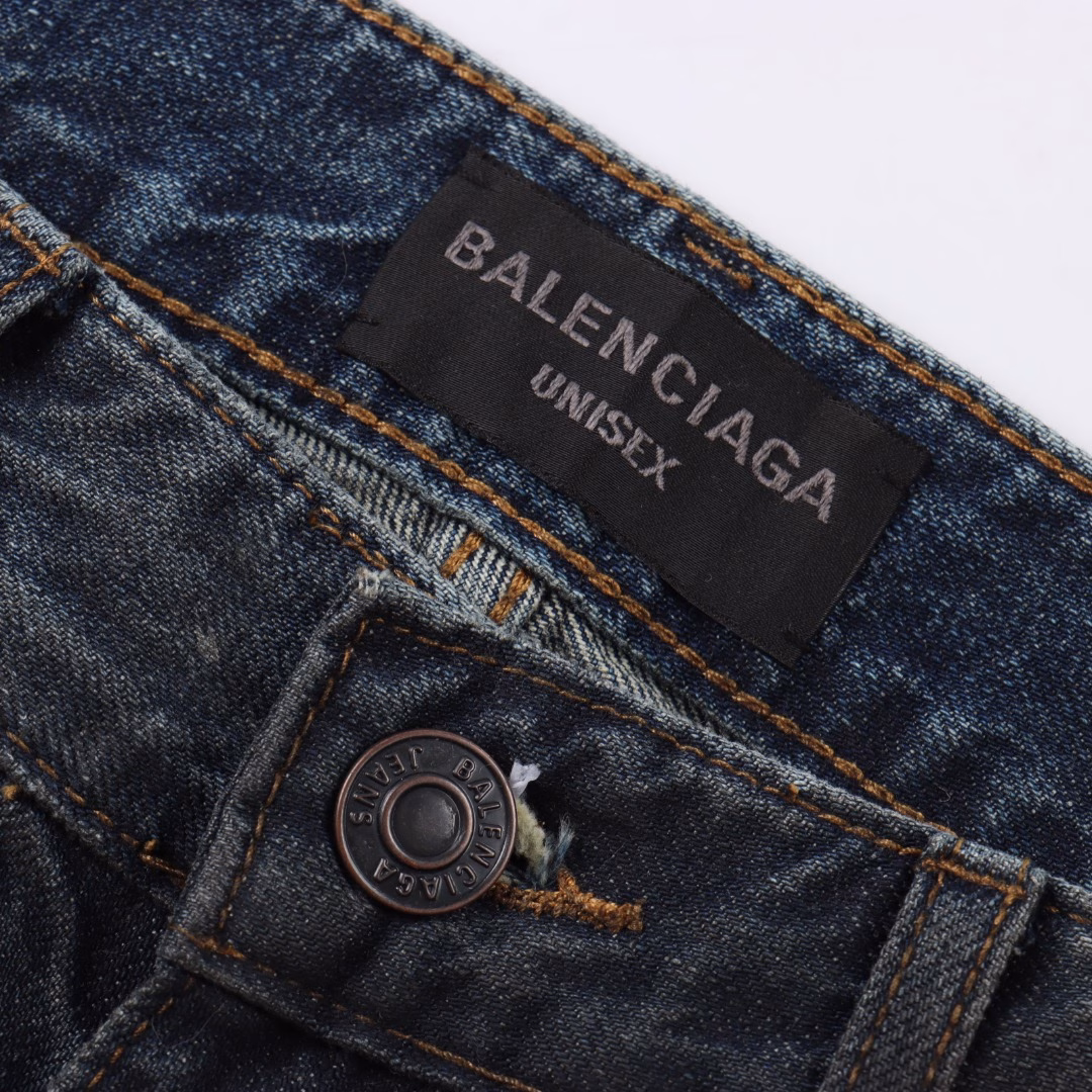 Balenciaga 25ss show low-rise denim trousersIt is made of high-density cotton denim fabric and processed through a special blending technique, incorporating a trace amount of elastic fibers to enhance wearing comfort. The fabric undergoes multiple stages of water washing treatment, including enzyme washing, stone grinding and hand brushing, to create a natural fading effect and present a retro and aged texture. The yarn is spun by ring spinning technology to enhance the fabric's toughness and texture layering, ensuring a balance between stiffness and softness. Based on the classic straight-leg style, the leg line is optimized through precise three-dimensional cutting. The front and back pieces are slightly conical spliced to ensure a drape while avoiding bulkiness. The waistband design may incorporate hidden adjustment loops to balance fit and minimalist aesthetics. The buttons are made of specially designed alloy materials. The surface has undergone an aged coating treatment, engraved with the brand's signature LOG. The rivets and zippers are made of the same series of metals and have passed salt spray tests to ensure oxidation resistance. At the same time, it maintains a rough industrial style, echoing the overall retro tone. Through the integration of deconstructionism and street style, the craftsmanship details are transformed into visual language - such as deliberately retained unfinished burrs, asymmetrical dyeing, etc. Strengthen the brand's rebellious spirit while maintaining the practicality of high-end items