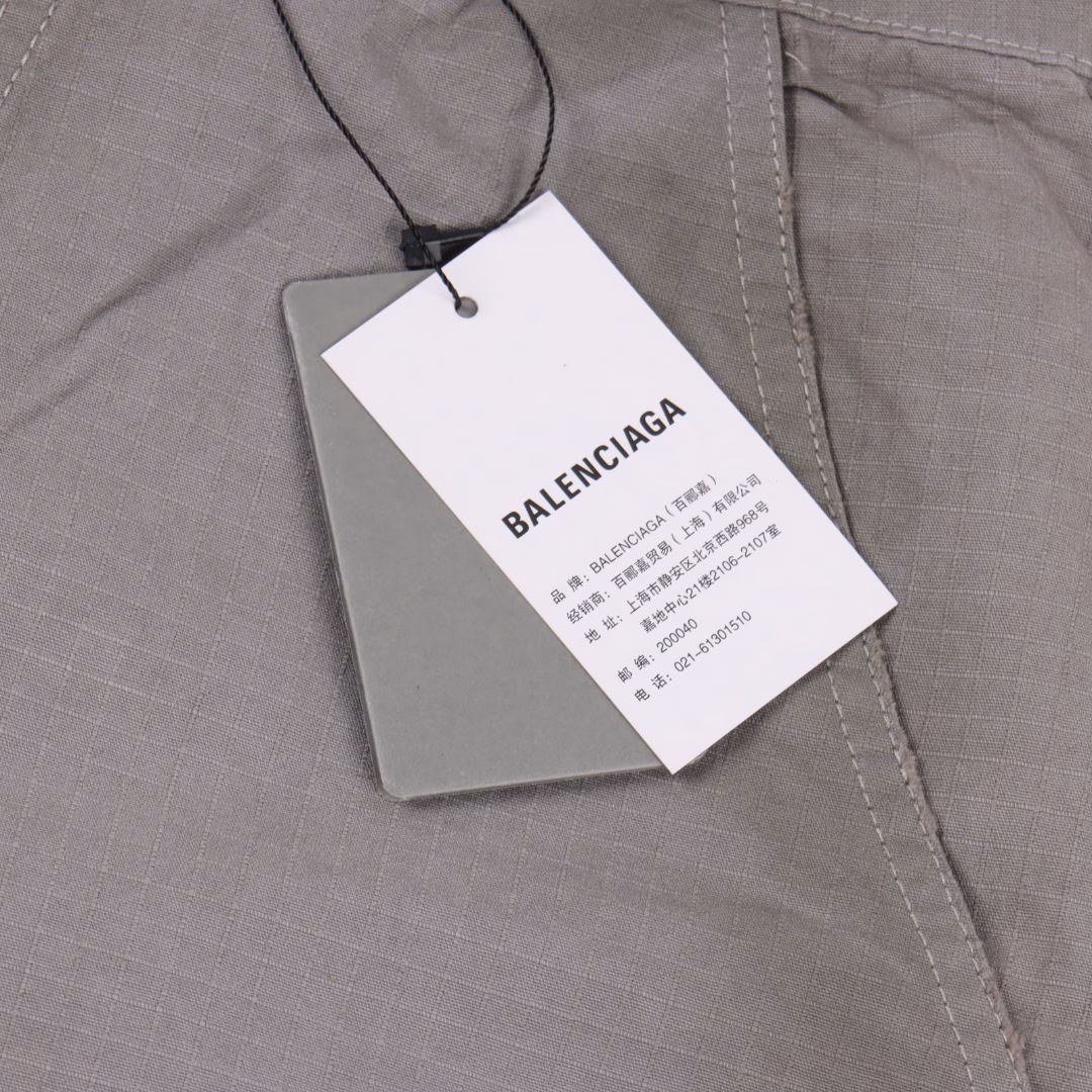 Balenciaga 25ss Loop distressed work shortsThe workwear pants are reconfigured with advanced customization techniques to achieve functional design. The main body is made of high-count, high-density checkered woven fabric, which undergoes multiple washing processes to present an aged texture. It is then superimposed with a spray-painted fastener process, a high-precision sandblasting + enzyme washing technology, to create a three-dimensional aged effect. The deliberate aging creates natural wrinkles and fading effects. All hardware parts are custom-made by brand molds. The zipper teeth and pull straps are electroplated with zinc alloy. It is engraved with the exclusive 