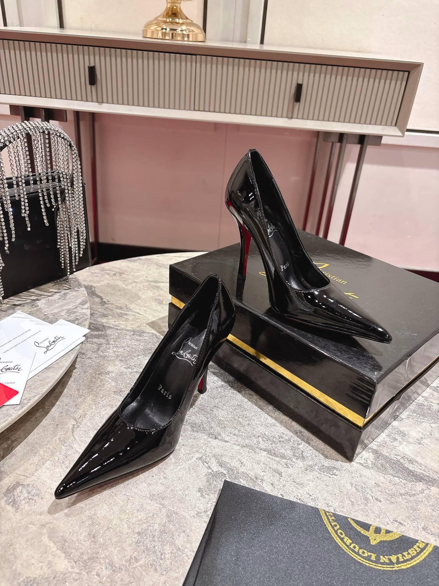 This pair of shoes features a 100mm high heel, revealing the iconic Loubi red sole, and is equipped with soft insoles made of black glossy calfskin. This shoe features a new 