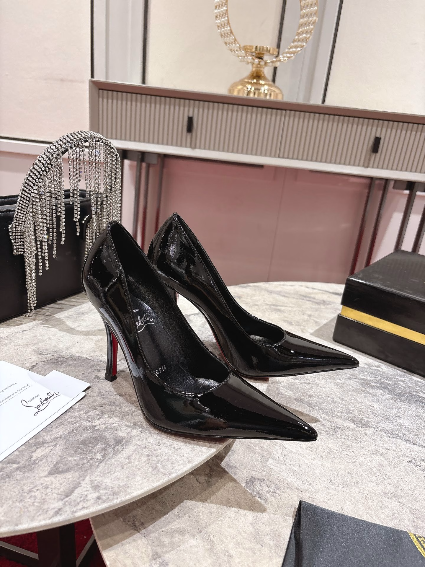 This pair of shoes features a 100mm high heel, revealing the iconic Loubi red sole, and is equipped with soft insoles made of black glossy calfskin. This shoe features a new 