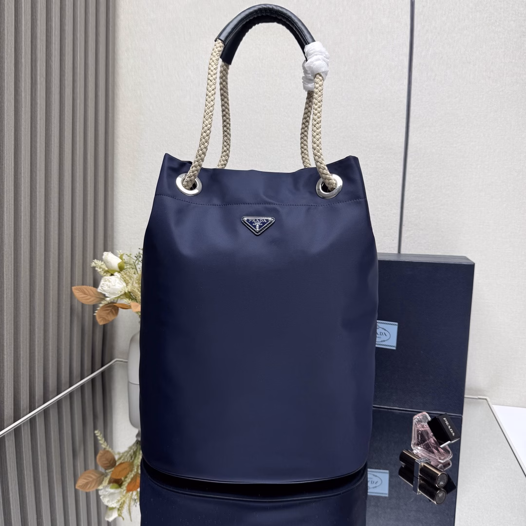 The design of this Re-Nylon handbag is made of nylon fabric and calfskin. The unique combination adds charming embellishments. The sliding rope handle highlights the flexibility and versatility of this handbag, making it convenient to carry by hand, shoulder or cross diagonally. It is made of top-quality hardware. It has a large capacity and space, is very casual and fashionable, and is another timeless bestseller. Kids, hurry up and get it