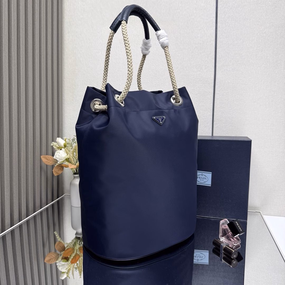 The design of this Re-Nylon handbag is made of nylon fabric and calfskin. The unique combination adds charming embellishments. The sliding rope handle highlights the flexibility and versatility of this handbag, making it convenient to carry by hand, shoulder or cross diagonally. It is made of top-quality hardware. It has a large capacity and space, is very casual and fashionable, and is another timeless bestseller. Kids, hurry up and get it