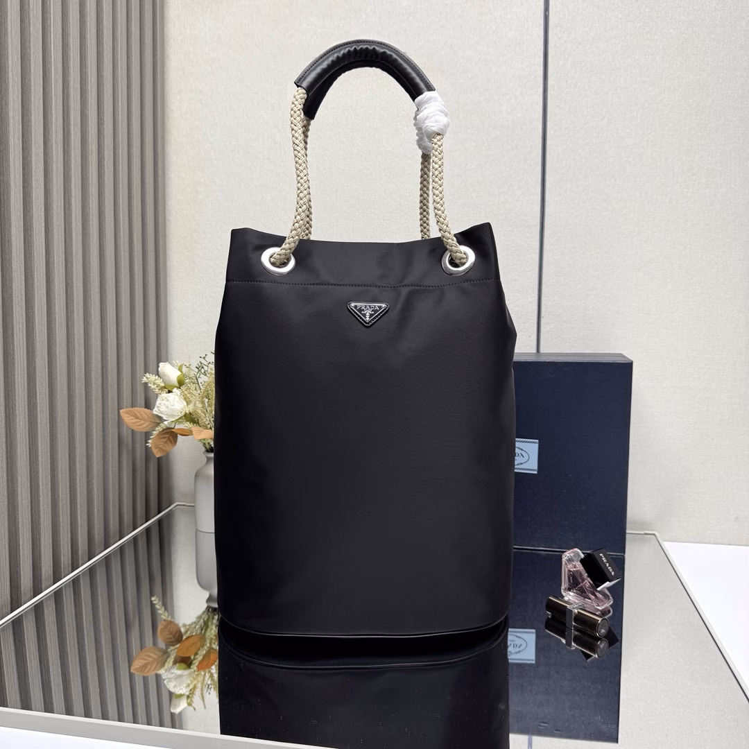 The design of this Re-Nylon handbag is made of nylon fabric and calfskin. The unique combination adds charming embellishments. The sliding rope handle highlights the flexibility and versatility of this handbag, making it convenient to carry by hand, shoulder or cross diagonally. It is made of top-quality hardware. It has a large capacity and space, is very casual and fashionable, and is another timeless bestseller. Kids, hurry up and get it