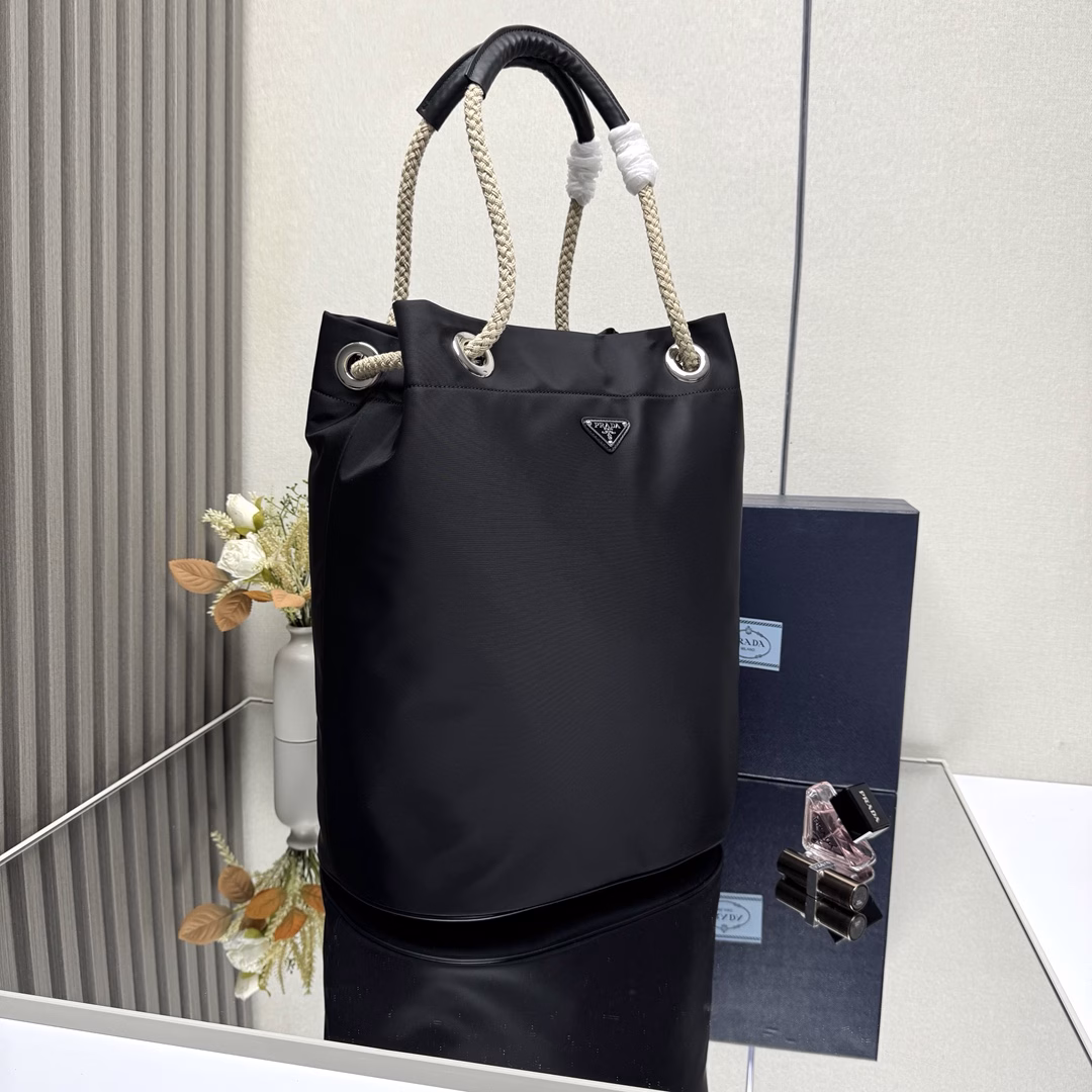 The design of this Re-Nylon handbag is made of nylon fabric and calfskin. The unique combination adds charming embellishments. The sliding rope handle highlights the flexibility and versatility of this handbag, making it convenient to carry by hand, shoulder or cross diagonally. It is made of top-quality hardware. It has a large capacity and space, is very casual and fashionable, and is another timeless bestseller. Kids, hurry up and get it