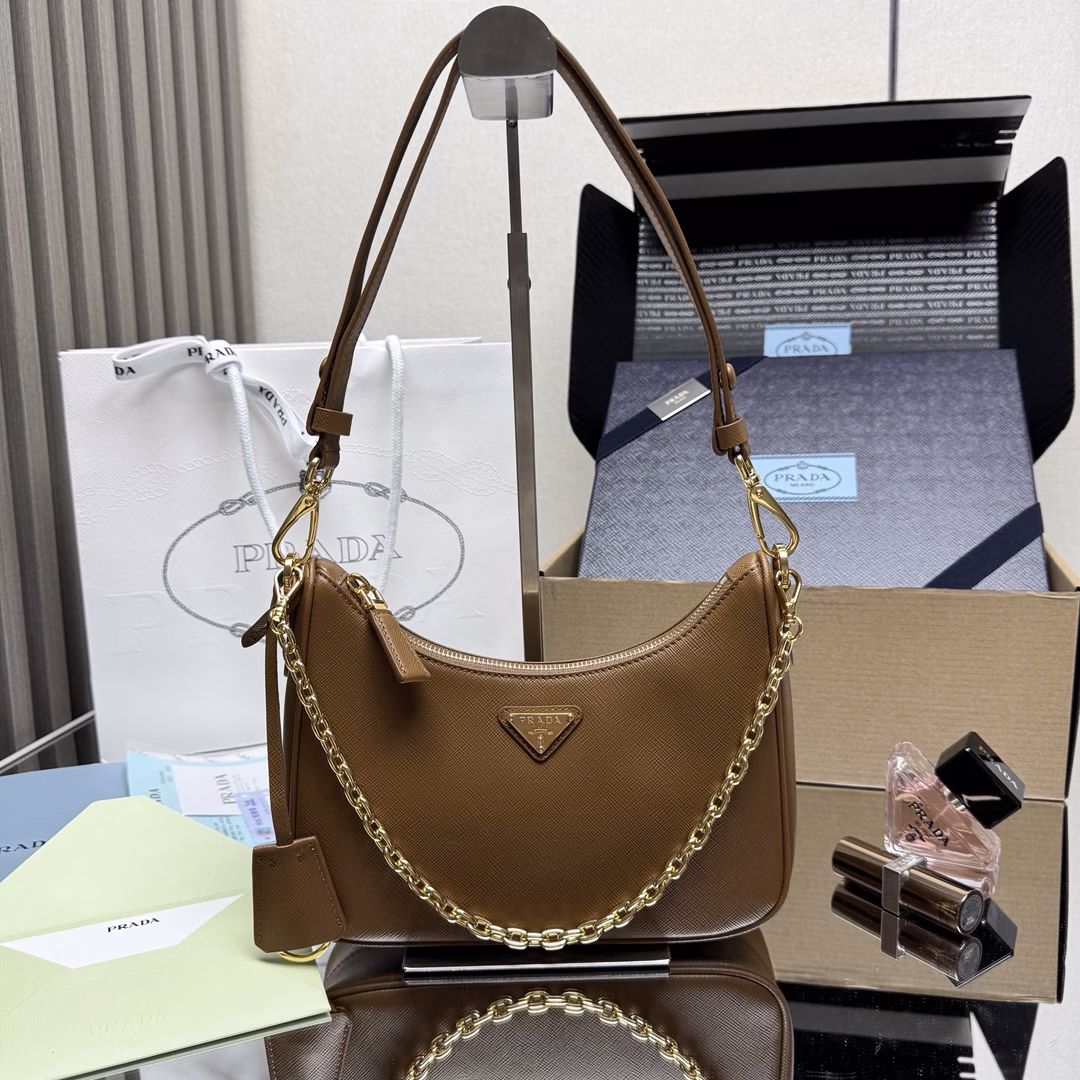 The newly upgraded Hobo🎉 strap detachable 🎉 This versatile handbag features sleek lines and classic details, paired with a detachable chain and adjustable long shoulder strap, and can be carried by hand or crossbody. It is made of Saffiano leather and adorned with a distinctive enameled triangular metal logo. Here comes another timeless bestseller. Kids, hurry up and get it