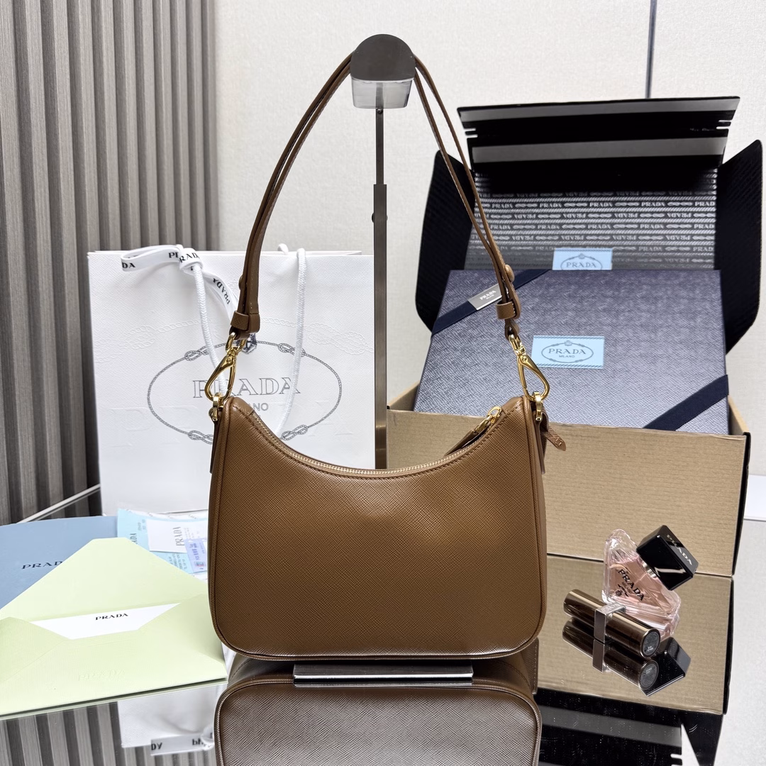 The newly upgraded Hobo🎉 strap detachable 🎉 This versatile handbag features sleek lines and classic details, paired with a detachable chain and adjustable long shoulder strap, and can be carried by hand or crossbody. It is made of Saffiano leather and adorned with a distinctive enameled triangular metal logo. Here comes another timeless bestseller. Kids, hurry up and get it