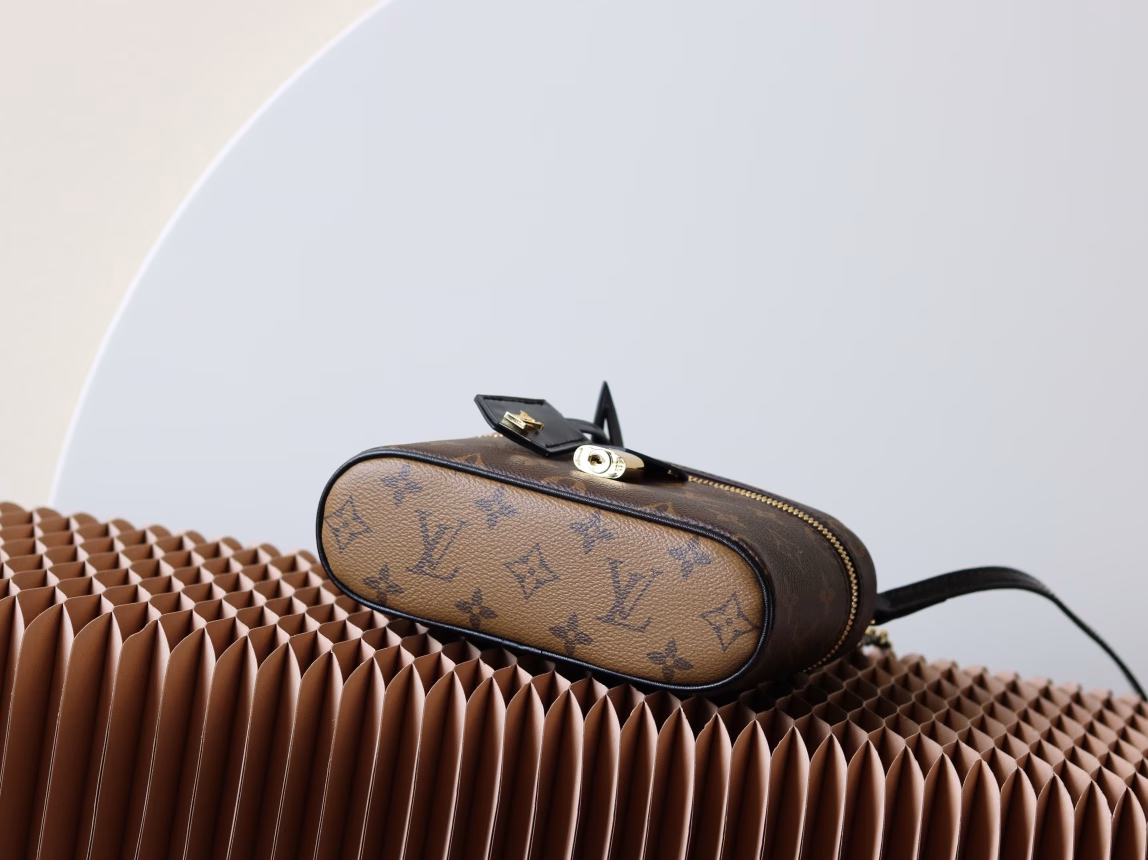 The Vanity Chain Pouch handbag draws inspiration from classic cosmetic cases and interprets the spirit of travel with Monogram canvas. The top handle and detachable woven chain incorporate leather elements, complementing the simple lines of the bag body. The LV signature padlock and leather key case continue the iconic details