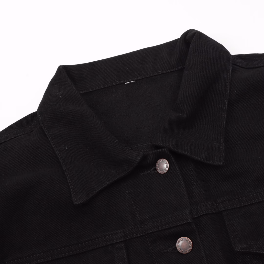 Prada PRD denim jacket with triangular logo on the hemCustom-made high-density Phantom twill satin with fine velvet, equipped with an imported infrared positioning machine for more precise positioning, is firm and sturdy. The first step is to position the spray horse fastener and then create a gradient effect by hand rubbing. Use a spray gun to precisely spray the reagent solution onto the designated position on the shirt according to the design requirements, allowing the reagent to undergo a chemical reaction with the fabric to form a gradual gradient effect. Finally, water boiling is used to reinforce the color. Follow the original color series to do the Biwen dyeing color matching. First, based on the original color and fabric material, select the specially made Biwen dyeing dye, then heat it to the appropriate temperature for immersion dyeing treatment. Finally, carry out the color matching implementation, customize the auxiliary materials, and create a fitted pattern