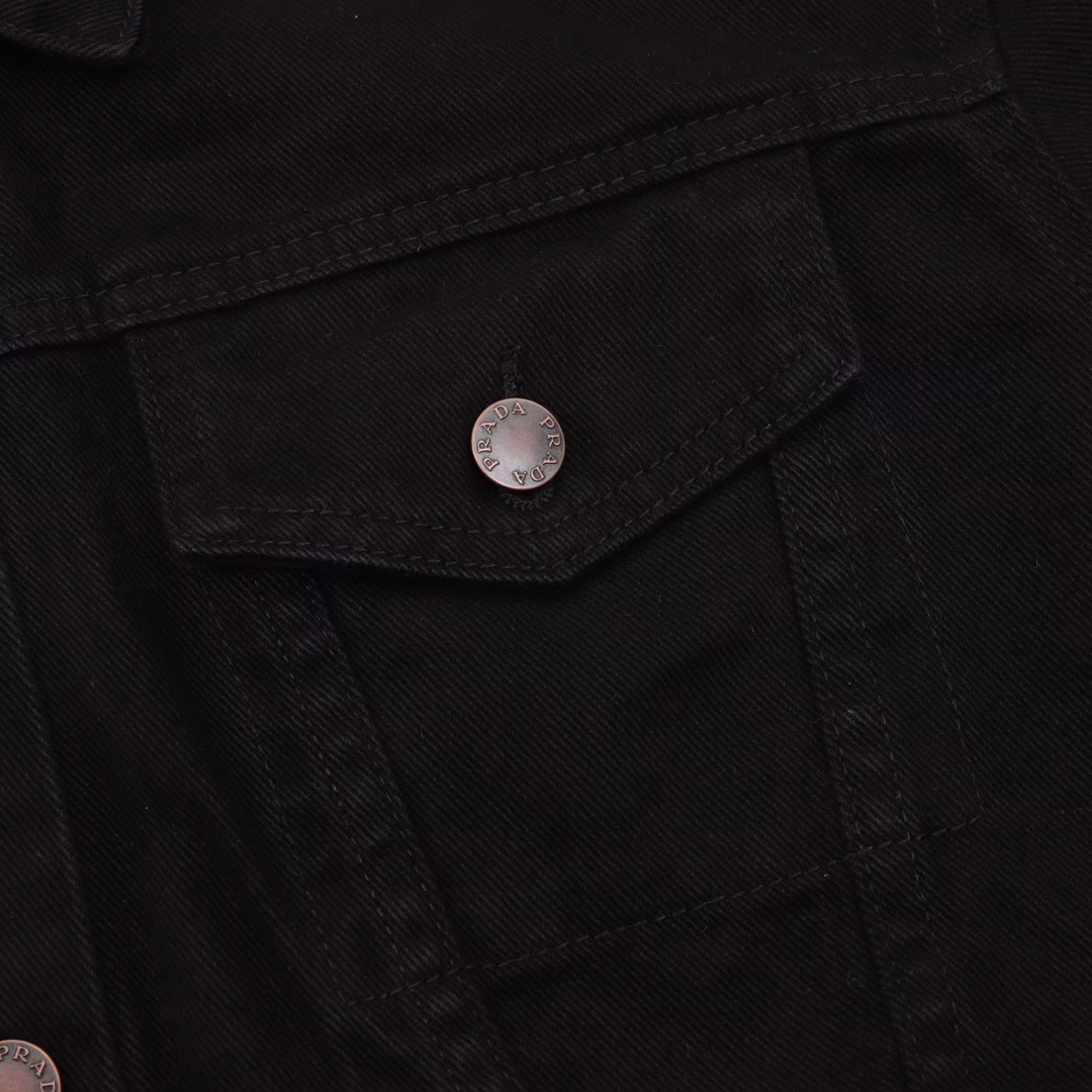 Prada PRD denim jacket with triangular logo on the hemCustom-made high-density Phantom twill satin with fine velvet, equipped with an imported infrared positioning machine for more precise positioning, is firm and sturdy. The first step is to position the spray horse fastener and then create a gradient effect by hand rubbing. Use a spray gun to precisely spray the reagent solution onto the designated position on the shirt according to the design requirements, allowing the reagent to undergo a chemical reaction with the fabric to form a gradual gradient effect. Finally, water boiling is used to reinforce the color. Follow the original color series to do the Biwen dyeing color matching. First, based on the original color and fabric material, select the specially made Biwen dyeing dye, then heat it to the appropriate temperature for immersion dyeing treatment. Finally, carry out the color matching implementation, customize the auxiliary materials, and create a fitted pattern