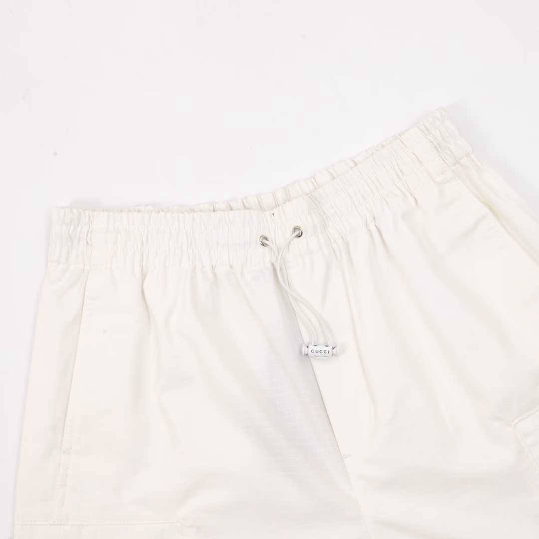 Gucci's white casual sports shorts with red and green letter prints on the backYB purchased a pattern, made of custom cotton fabric, which is comfortable, soft, skin-friendly and breathable. The front has a slanted pocket and a large flip pocket. The design is simple, with elastic bands for the waist circumference. The white drawstring is paired with engraved hardware. The back is covered with fabric pocket details, decorated with red and green stripe prints and brand letters. It can be matched with various types of clothing to create a fashionable look. Custom accessories are available. All three labels are complete. It is suitable for both men and women!