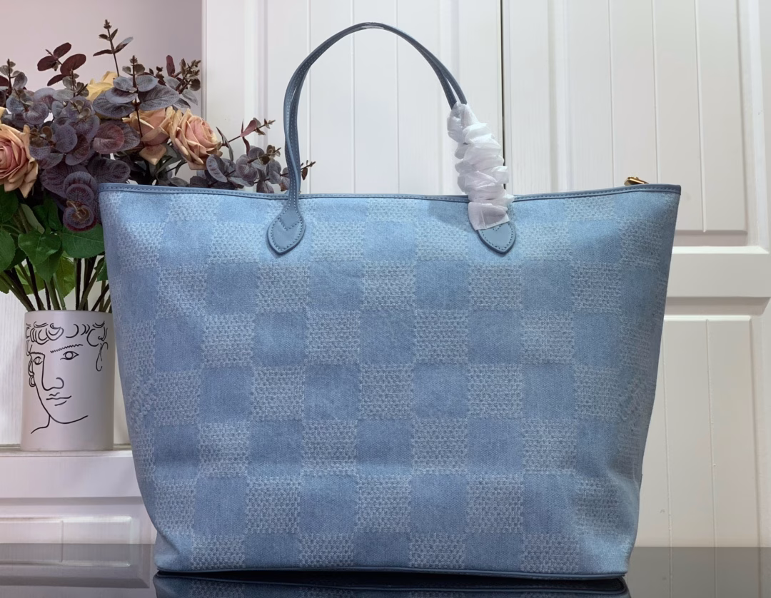 This Nevereverfull tote is crafted from Damier Denim 3D cotton canvas with a chic check pattern, finished with polished hardware and leather trims. The zip fastening allows for plenty of space, and the removable cotton denim canvas pocket provides ample storage for your belongings.