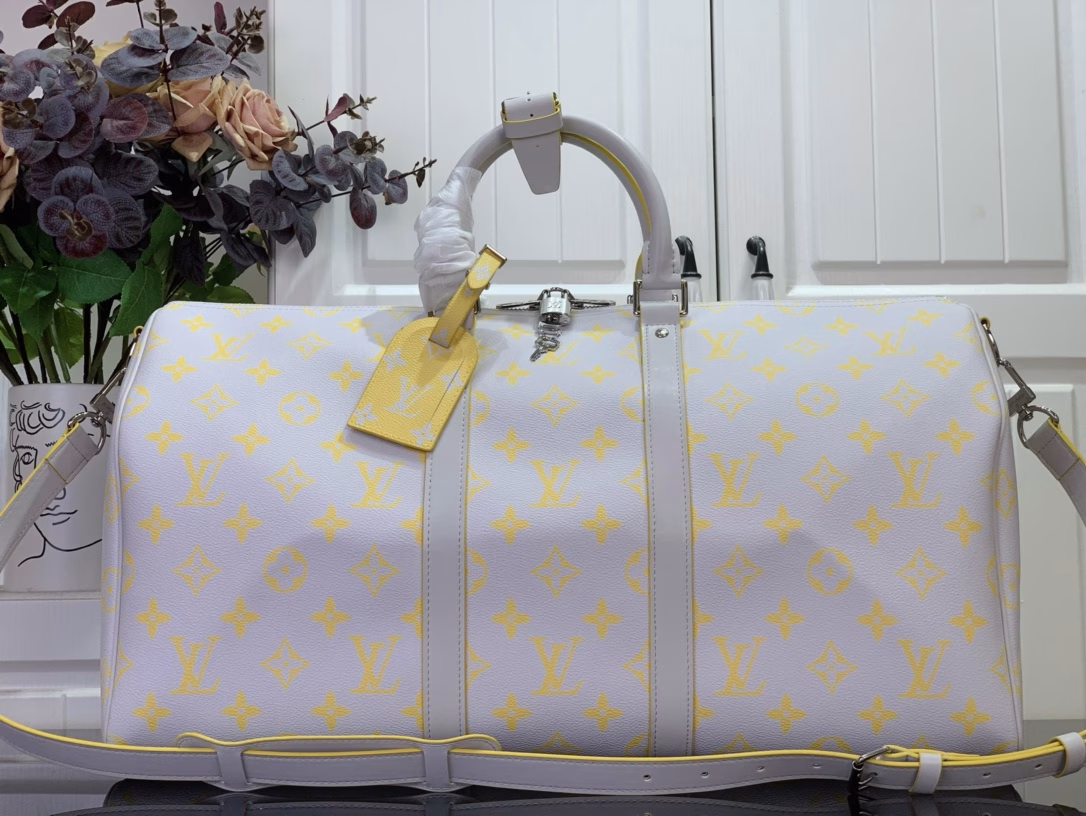 The Keepall Bandoulière 50 travel bag is crafted from colorful Monogram Glow canvas with a contrasting Monogram pattern on the fabric lining and branding. Leather side straps, top handles and a removable shoulder strap continue the color palette, while distressed hardware completes the look.