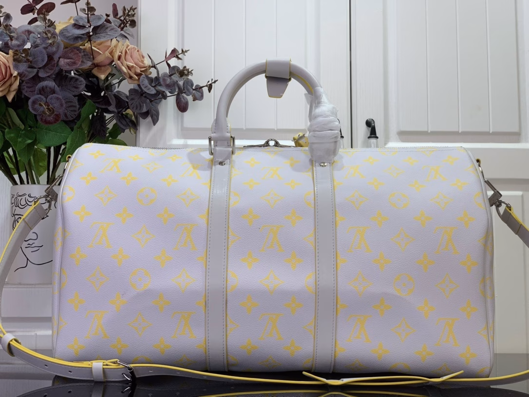 The Keepall Bandoulière 50 travel bag is crafted from colorful Monogram Glow canvas with a contrasting Monogram pattern on the fabric lining and branding. Leather side straps, top handles and a removable shoulder strap continue the color palette, while distressed hardware completes the look.