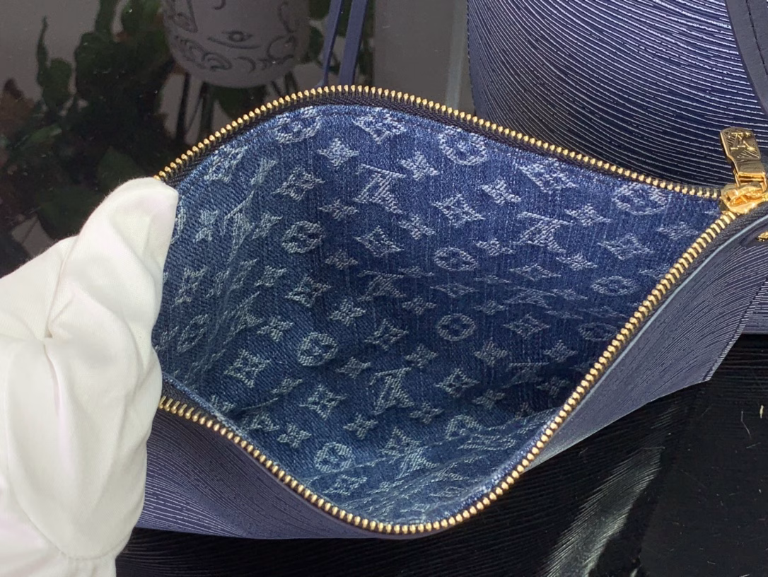 The Neverfull MM bag strikes a balance between direction and timelessness in a cool denim blue finish. It is made from iconic Epi leather and embellished with gold hardware. The interior offers a removable monogram zip pocket and is lined with monogram denim. Use the side laces to tighten the silhouette, wear it over the shoulder or carry it by hand.